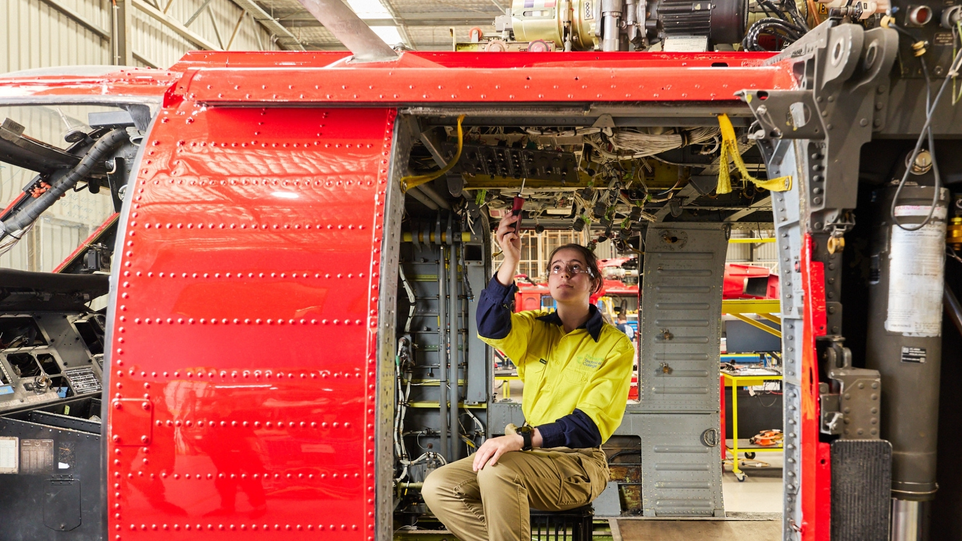 Aeroskills student working on wiring inside the cabin of an aircraft during practical training.